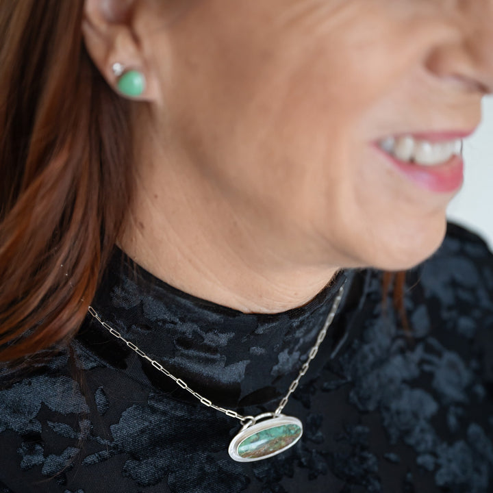 The unique 'surfboard' shaped cabochon inspired me to set it horizontally, creating a scene that captures the serene beauty of ocean depths—where stunning blue-green waters meet the shore.