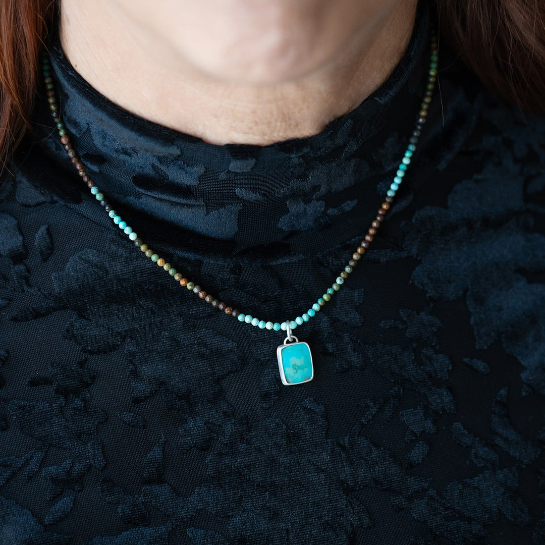 Enjoy summer vibes all year with this Turquoise Beaded Pendant Necklace. The swirly sky blue turquoise pendant, set in sterling silver, is strung on a delicate ombre Turquoise beaded necklace.