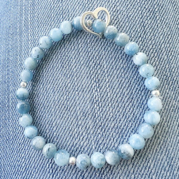 A beautiful aquamarine and sterling silver heart charm bracelet! Featuring a deep blue aquamarine - like ocean waves crashing on the beach -- this romantic design promises to bring you joy. Treat yourself or a loved one to this stunning and heartfelt gift!