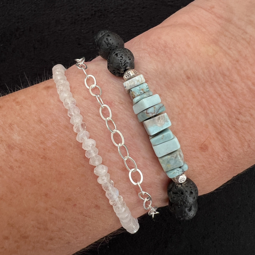 The pale ice blue Larimer square-cut beads are a powerful combination of black lava rock and sterling silver spacer beads. Pair this with the Rainbow Moonstone and Sterling Silver Chain bracelet for your next summer bracelet stack.