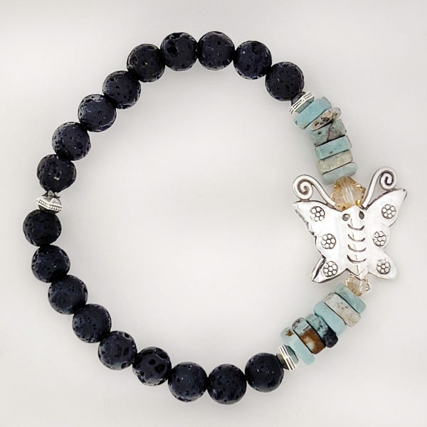 Unlock nature's beauty with the Butterfly Bliss Larimar Bracelet! Featuring a fine silver butterfly charm and lava rock beads, this bracelet will make you feel like you can spread your wings and fly!