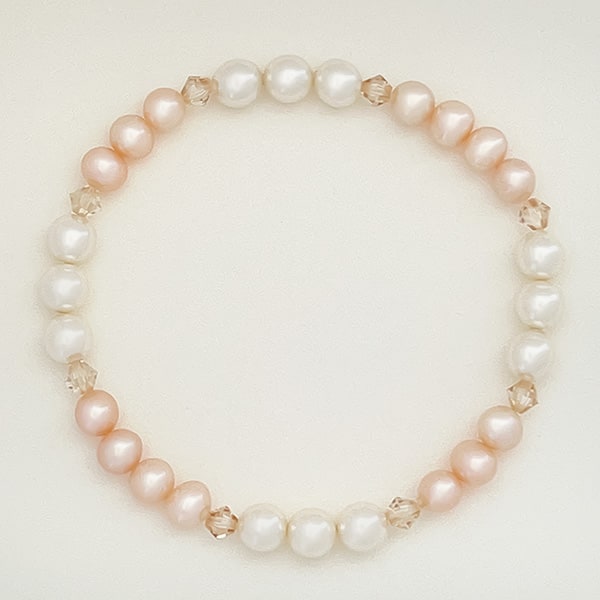 Showcase your love of luxury with this freshwater pearl and Swarovski crystal pearl bracelet. This piece features semi-round pearls in a beautiful cream-rose hue, paired with light cream rose Swarovski crystal pearls that add a hint of luminosity. The bracelet’s secure fit brings refined elegance to your look.