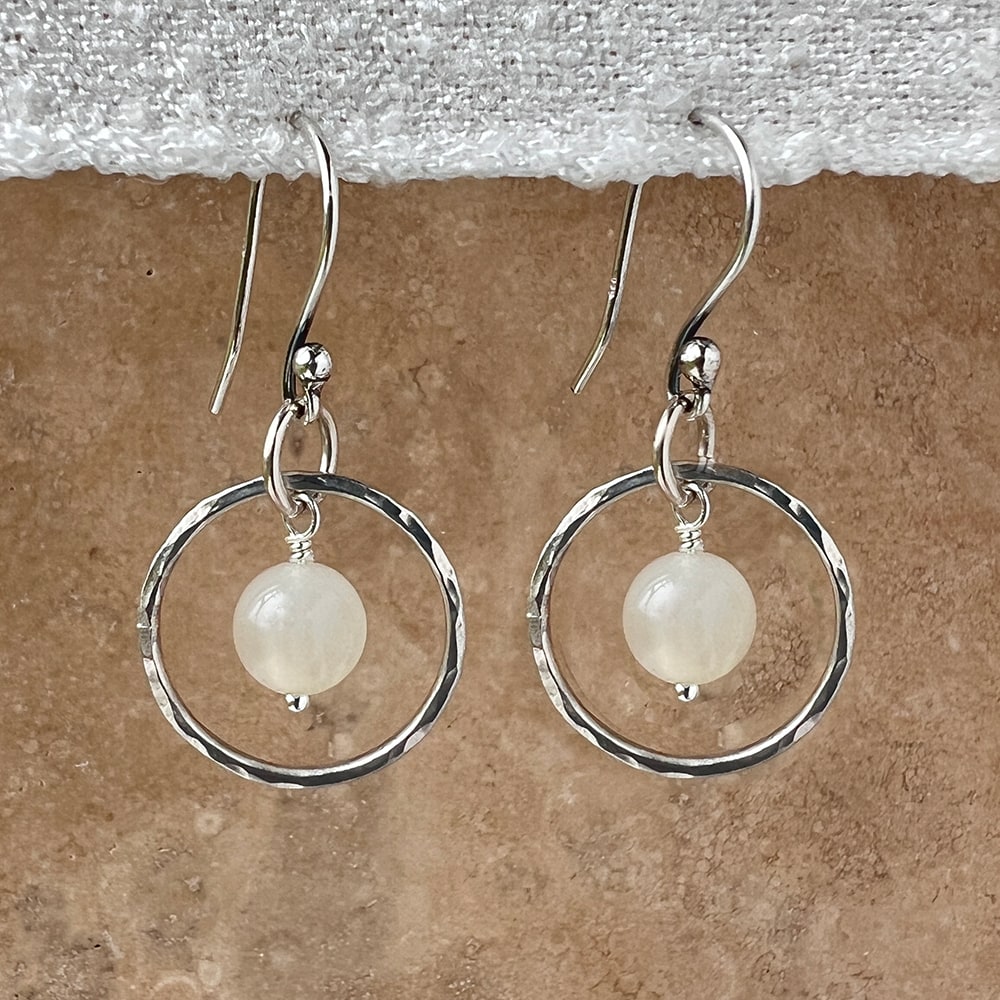 Elegantly crafted small sterling silver hoops adorned with creamy Moonstone Beads and a hammered texture. Perfect for adding a touch of simple elegance to any outfit. Handcrafted in CA.