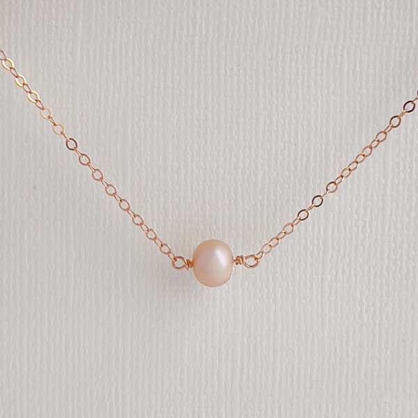 Elevate your look with this delicate layering pearl necklace. Featuring a single shimmery, creamy-rose colored pearl that is delicately set on a 14kt rose gold-filled chain, creating a luminous effect that captures the light beautifully.