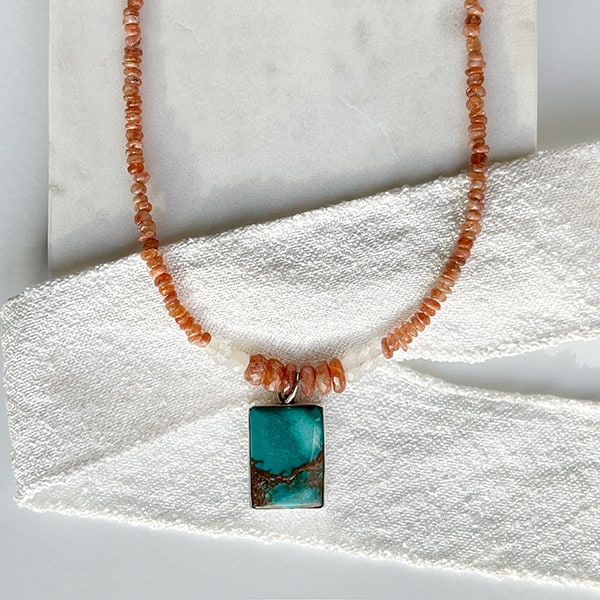 Turquoise and Sunstone Beaded Necklace shown on ribbon; Handcrafted in California