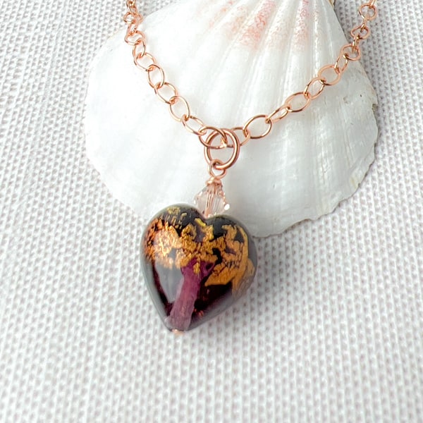 Adorn yourself with the romantic style of this amethyst Murano glass heart pendant necklace. This handmade piece features a mesmerizing amethyst glass heart bead with rich coverage of 24Kt gold foil covered in clear Murano glass which gives the bead a lovely depth.  Close up view