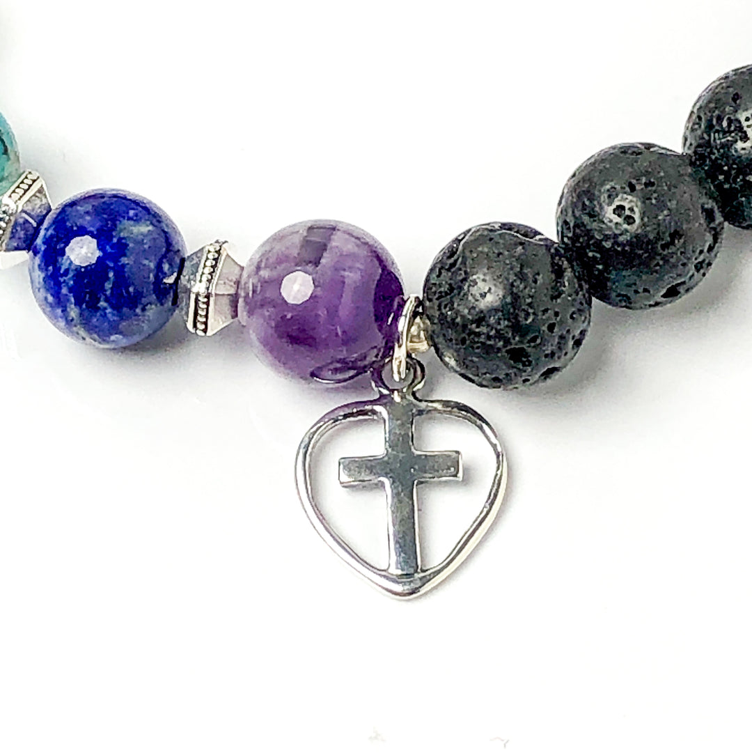 Semi-precious Gemstone 7 Chakra Bracelet, Sterling Silver Open Heart with Cross Charm, Lava Stone Bracelet, 8mm Beads, Handcrafted in CA.  This soul-inspired Chakra bracelet is handcrafted with 8mm lava & gemstone beads, Sterling Silver open heart cross charm, and antique silver-plated pewter spacers. Detail view of Cross charm.