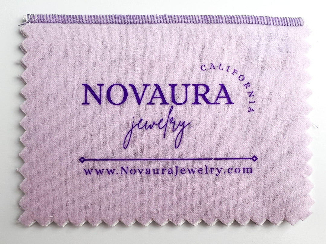 The two-piece Novaura Jewelry Polishing Cloth cleans, polishes, and prevents tarnish ten times longer! The inner white cloth gently and thoroughly cleans and removes tarnish, fingerprints, and body oils while also imparting a tarnish resistant barrier. The outer cloth buffs jewelry to a beautiful luster.