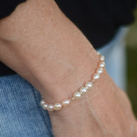 Showcase your love of luxury with this freshwater pearl and Swarovski crystal pearl bracelet. This piece features semi-round pearls in a beautiful cream-rose hue, paired with light cream rose Swarovski crystal pearls that add a hint of luminosity. The bracelet’s secure fit brings refined elegance to your look.Shown worn on wrist.