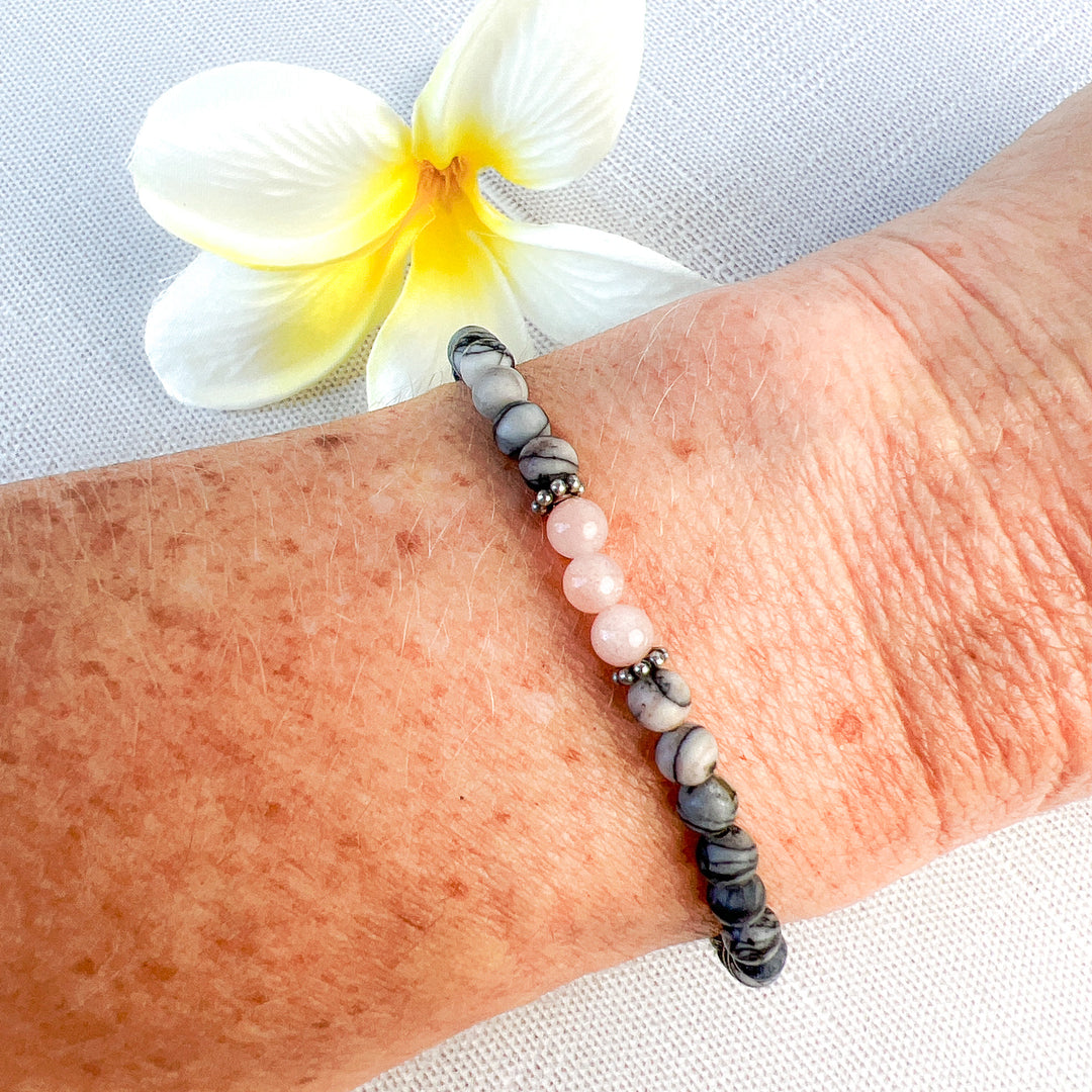 The lovely subtle pink of the moonstone contrasts nicely with the natural black silk stone and silver spacer beads. Part of the Novaura Jewelry Sparkle Set. Shown on wrist.