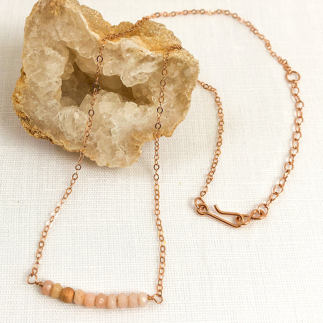 Delicate Pink Opal gemstone and Rose Gold-filled bar necklace. Perfect alone or for layering. The shine of the Rose Gold stardust bead compliments the opals nicely and gives the necklace an air of sophistication. Styled view. Handcrafted.