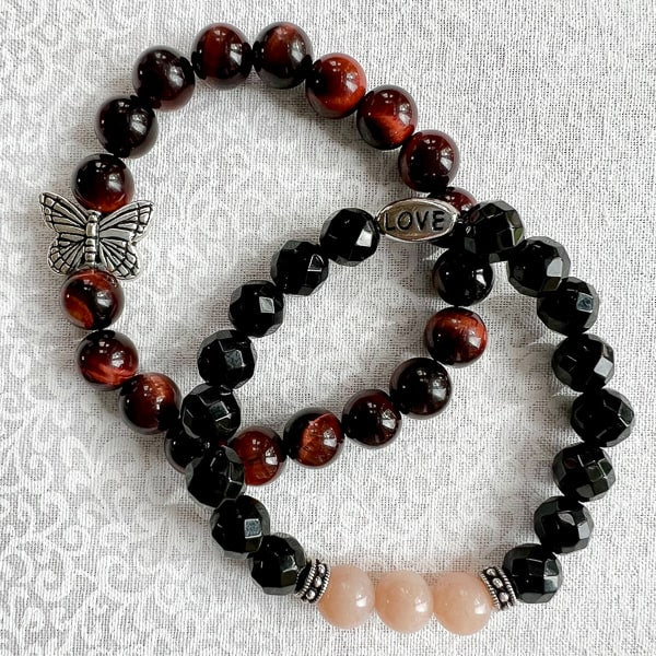 Butterfly Dreams Red Tigereye with Butterfly Charm bracelet. Deep rust red beads with whimsical butterfly charm. Shown with Novaura Jewelry's Pink Flake Moonstone & Black Onyx bracelet with LOVE bead. 